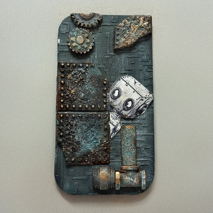 A decorative piece of art with a textured background in grey and a robot coming from behind the riveted plates. 