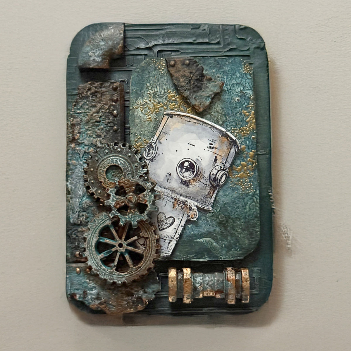 A wooden decorative piece with a robot peaking out from cogs on a teal background