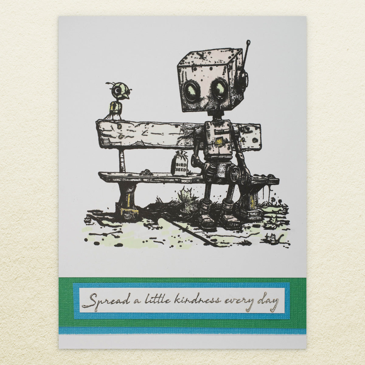 Stamp of a robot and a bird on a bench with a message saying 'Spread a little kindness every day'.