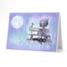 Greeting card with a robot and bird on a bench against a purple and blue watercolor background.