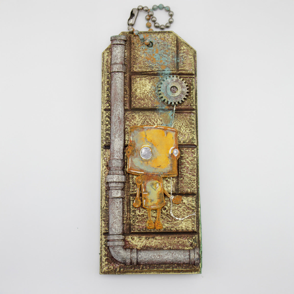 Decorative keychain with mechanical design with a robot holding a cog balloon and pipes on the bottom and the left on a white background