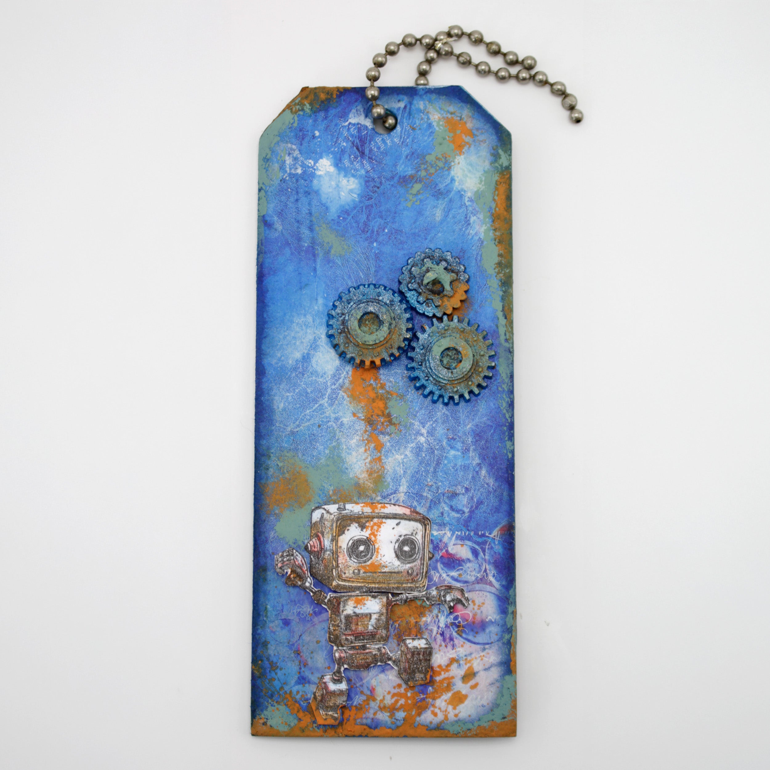 A tag with a blue background a robot at the bottom with cogs used to decorate. 